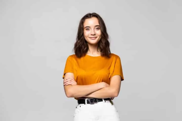 mulher com manga longa sorrindo e apontando com uma das mãos