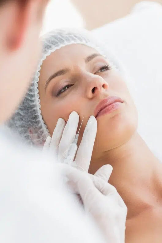 médica aplicando botox no rosto de uma mulher durante procedimento estético